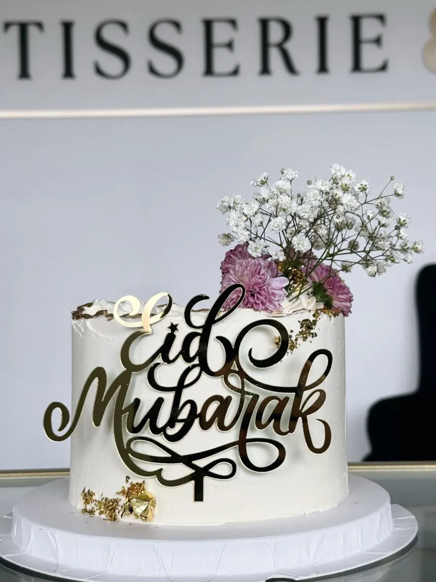 Gâteau Eid Mubarak posé devant le mur de la boutique et ses lettres Pâtisserie & Co