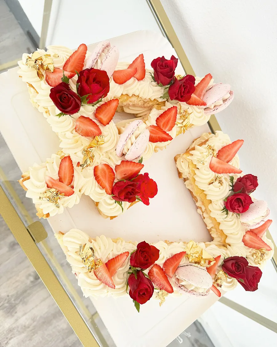 Number cake garni de crème, fraises, framboises, macarons et roses rouges